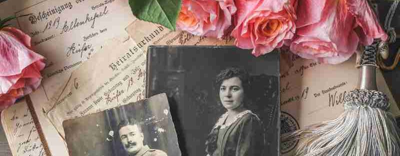 Antique family photographs with pink roses and historic documents., tags: eine die - pexel